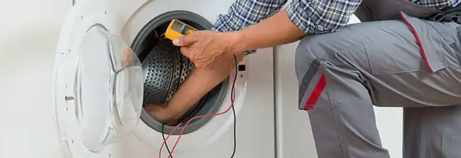 Dryer repair technician inspecting and repairing a clothes dryer in Lincoln, NE