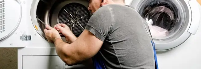 Dryer repair technician fixing a clothes dryer drum in Lincoln, NE