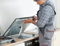 Appliance repair technician installing a built-in cooktop in Lincoln, NE