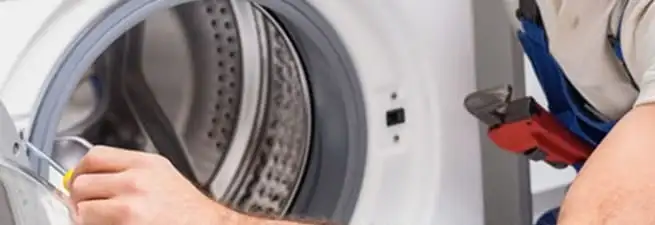 Appliance technician repairing a clothes dryer drum and internal parts in Lincoln, NE