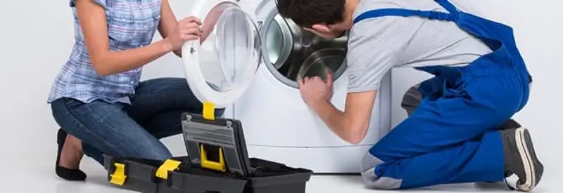 Washer repair technician inspecting a front-load washing machine with tools in Lincoln, NE