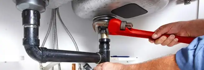 Garbage disposal repair technician tightening the sink drain and disposal connection in Lincoln, NE