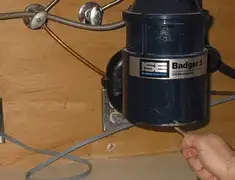 Garbage disposal repair technician tightening the mounting ring under a sink in Lincoln, NE