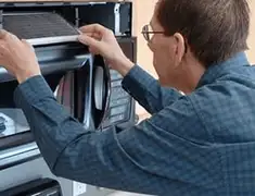 Appliance repair technician replacing a microwave vent filter in Lincoln, NE
