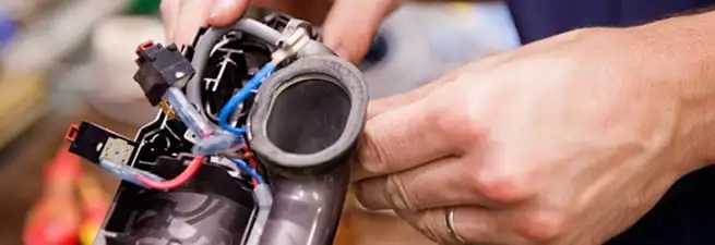 Vacuum repair technician reconnecting wiring and components in Lincoln, NE