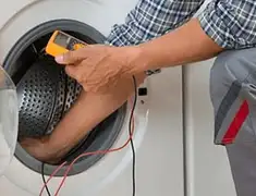 Washing machine repair technician testing a front-load washer with diagnostic tools in Lincoln, NE