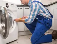 Washing machine repair technician servicing a front-load washer in Lincoln, NE