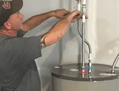 Water heater repair technician tightening supply line connections in Lincoln, NE