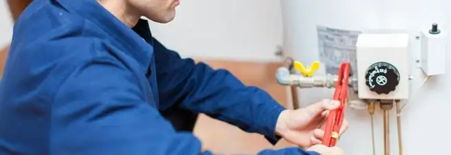 Water heater repair technician adjusting the temperature control and gas valve in Lincoln, NE